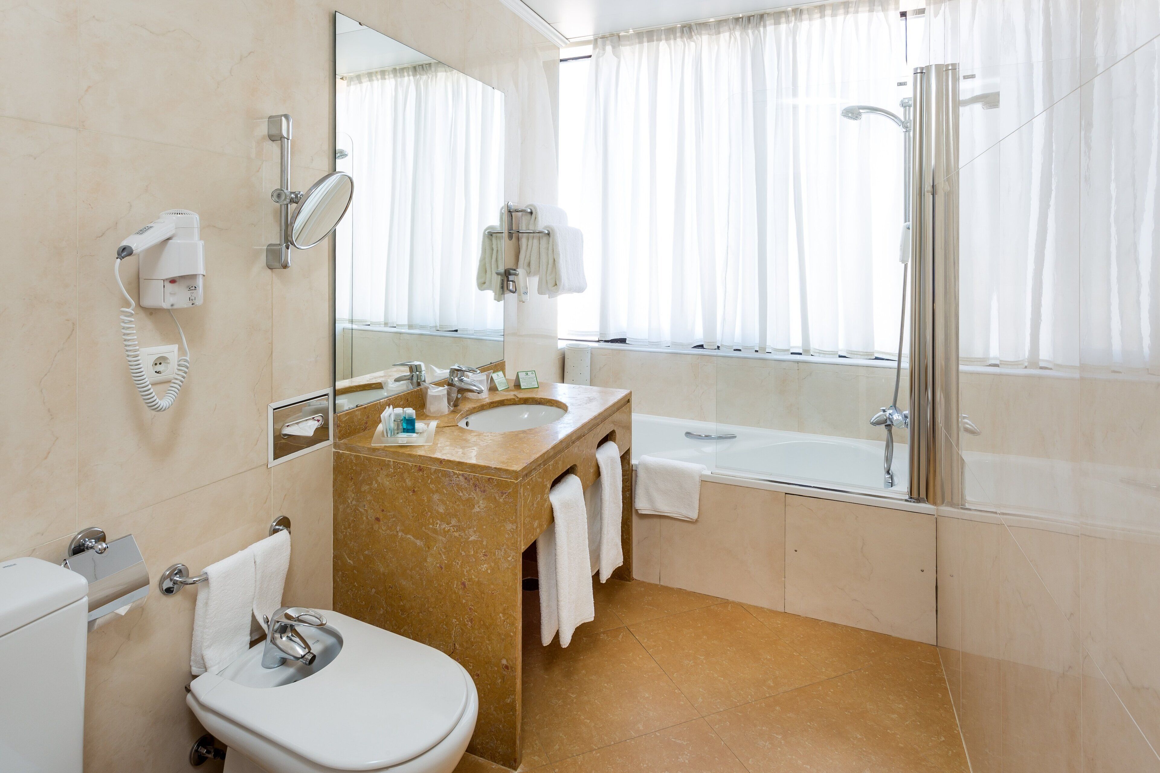 Een moderne badkamer met toilet, wastafel en douche.