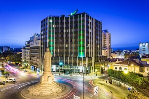 A modern hotel with a central courtyard, multiple floors, and a prominent entrance.