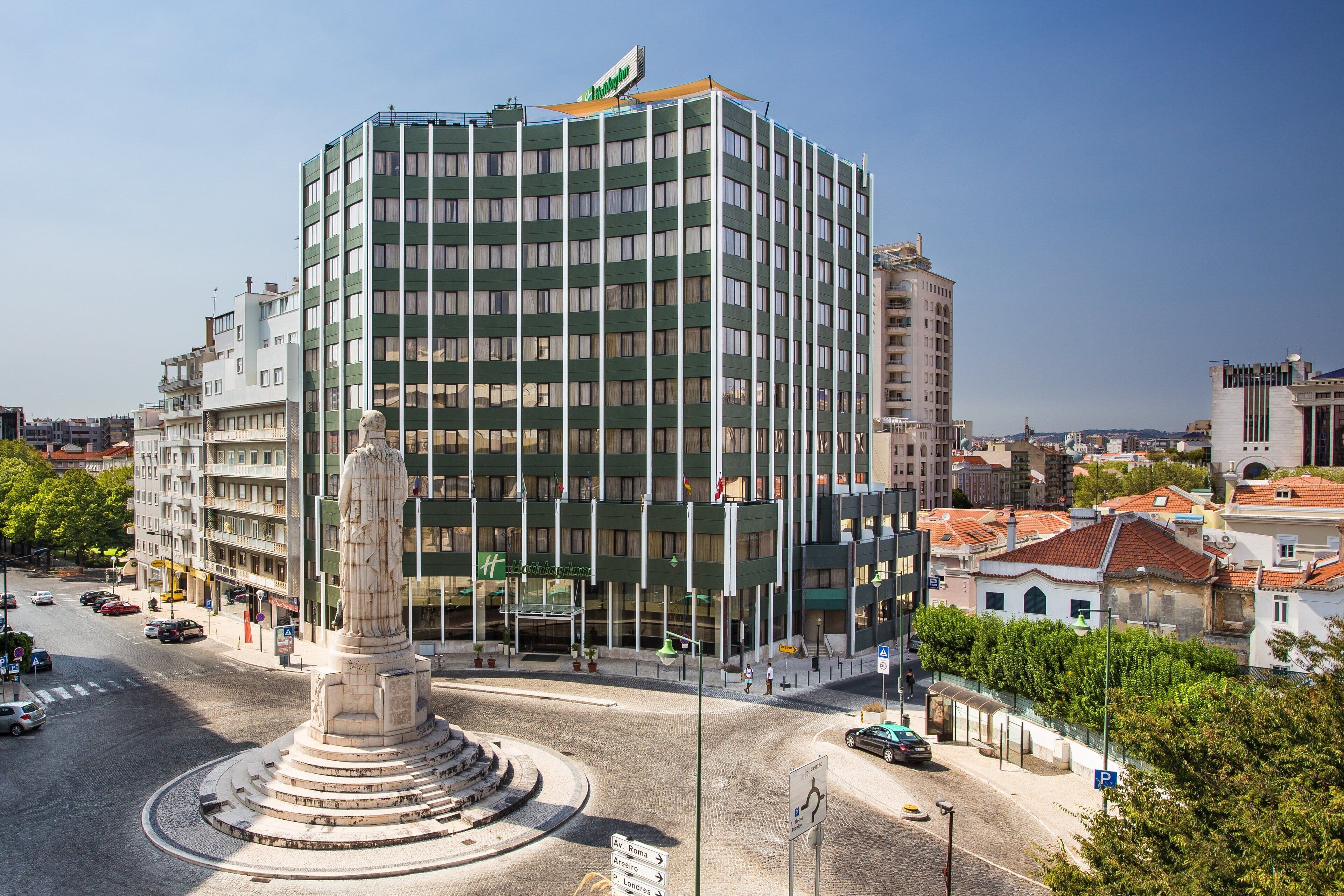 A modern hotel with a central courtyard and a statue.