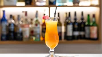 Un bicchiere da cocktail con una cannuccia e una mora come guarnizione su un bancone del bar.