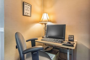 A hotel room with a desk, a computer, a chair, a lamp, and a printer. - Comfort Inn (Huntsville)