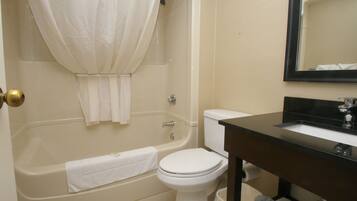 A bathroom with a bathtub, toilet, and sink.
