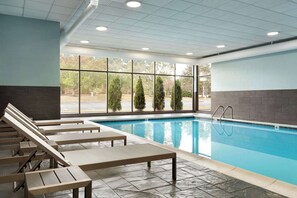 Una piscina techada, sillones reclinables de piscina