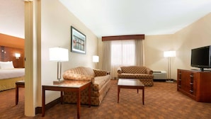 A hotel room with a bed, two sofas, a TV, and a desk. - Radisson Hotel Akron/Fairlawn (Akron)