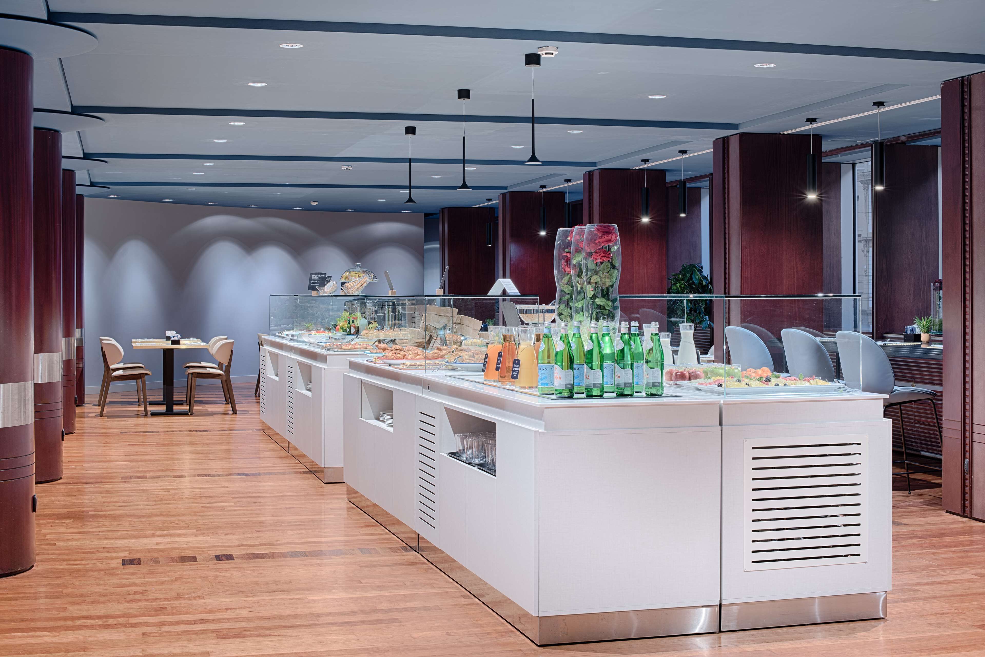 Een modern restaurant met een centrale balie, zitgedeelte en decoratieve details.