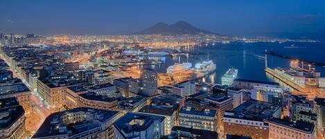 A cityscape at night with a prominent mountain in the background.