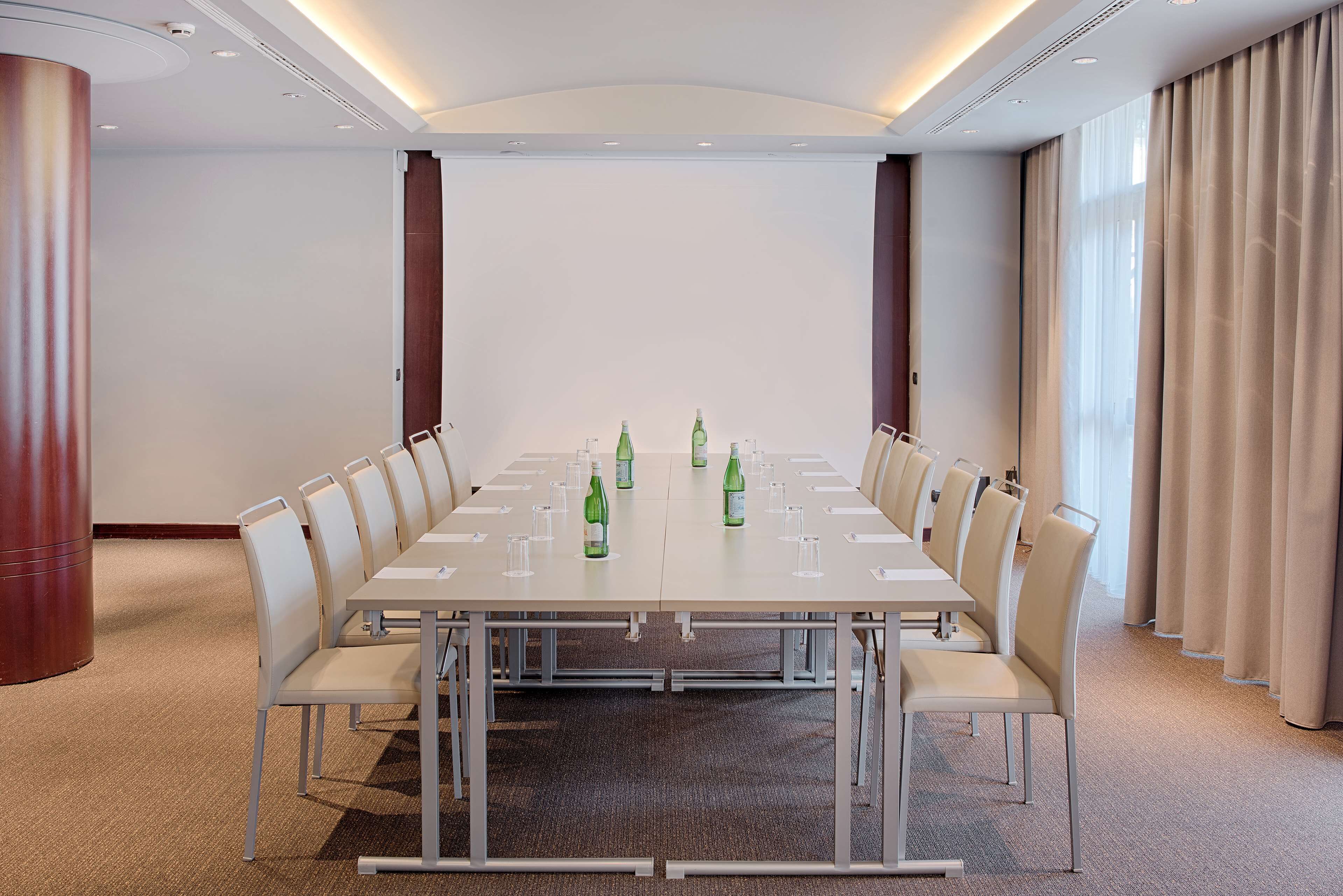 A conference room with a long table, chairs, and water bottles.