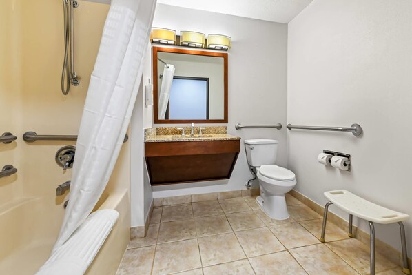 A bathroom with a shower, toilet, and a small step stool.