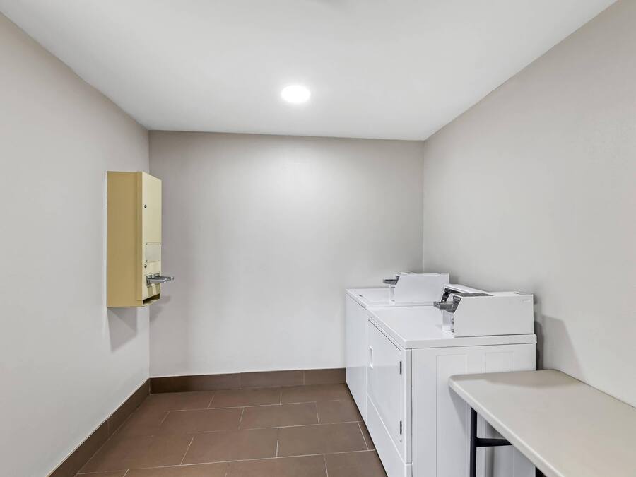 A laundry room with a washing machine, dryer, and a small sink.