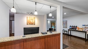 A reception area with a wooden counter, a digital screen, and pendant lighting.