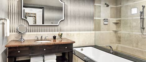 A modern bathroom with a large mirror, a dark wooden vanity, a bathtub, and a shower area.