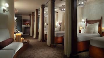 A hotel room with a large bed, a smaller bed, a sofa, and a nightstand with a lamp.