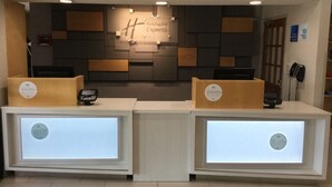 A reception area with two reception desks, a wall-mounted sign reading "Holiday Inn Express," and a telephone on the right side. - Holiday Inn Express Easton by IHG (Easton)