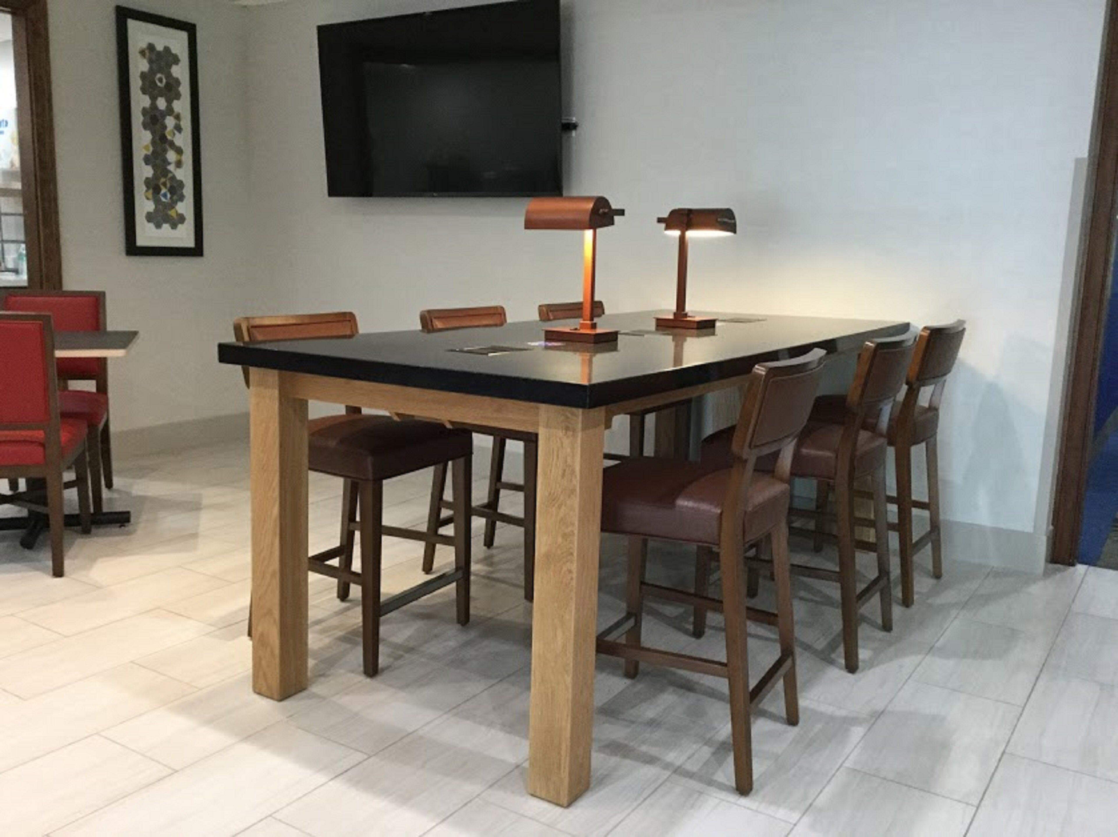 Een eetruimte met een rechthoekige tafel, zes stoelen en twee vloerlampen.