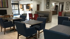 A modern hotel lobby with multiple seating areas, including tables and chairs, and a reception desk. - Holiday Inn Express Easton by IHG (Easton)