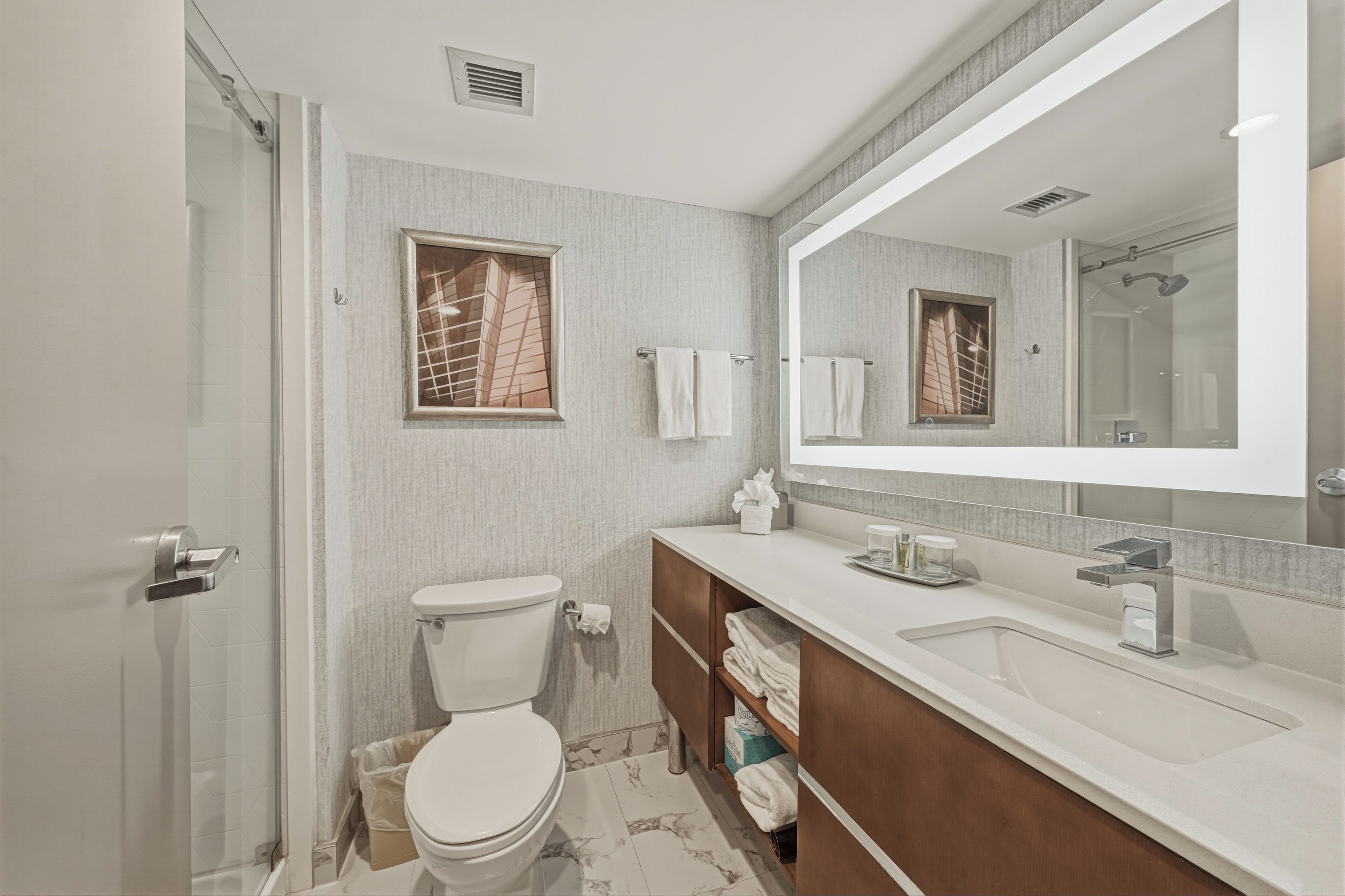 A modern bathroom with a toilet, sink, and shower area.