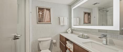 A modern bathroom with a toilet, sink, and shower area.