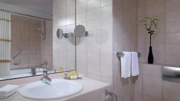 Ein Badezimmer mit Waschbecken, Spiegel, Handtuchhalter und einer Topfpflanze.