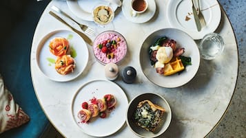 Une table où l’on trouve divers plats, notamment du saumon, des baies et une tarte.