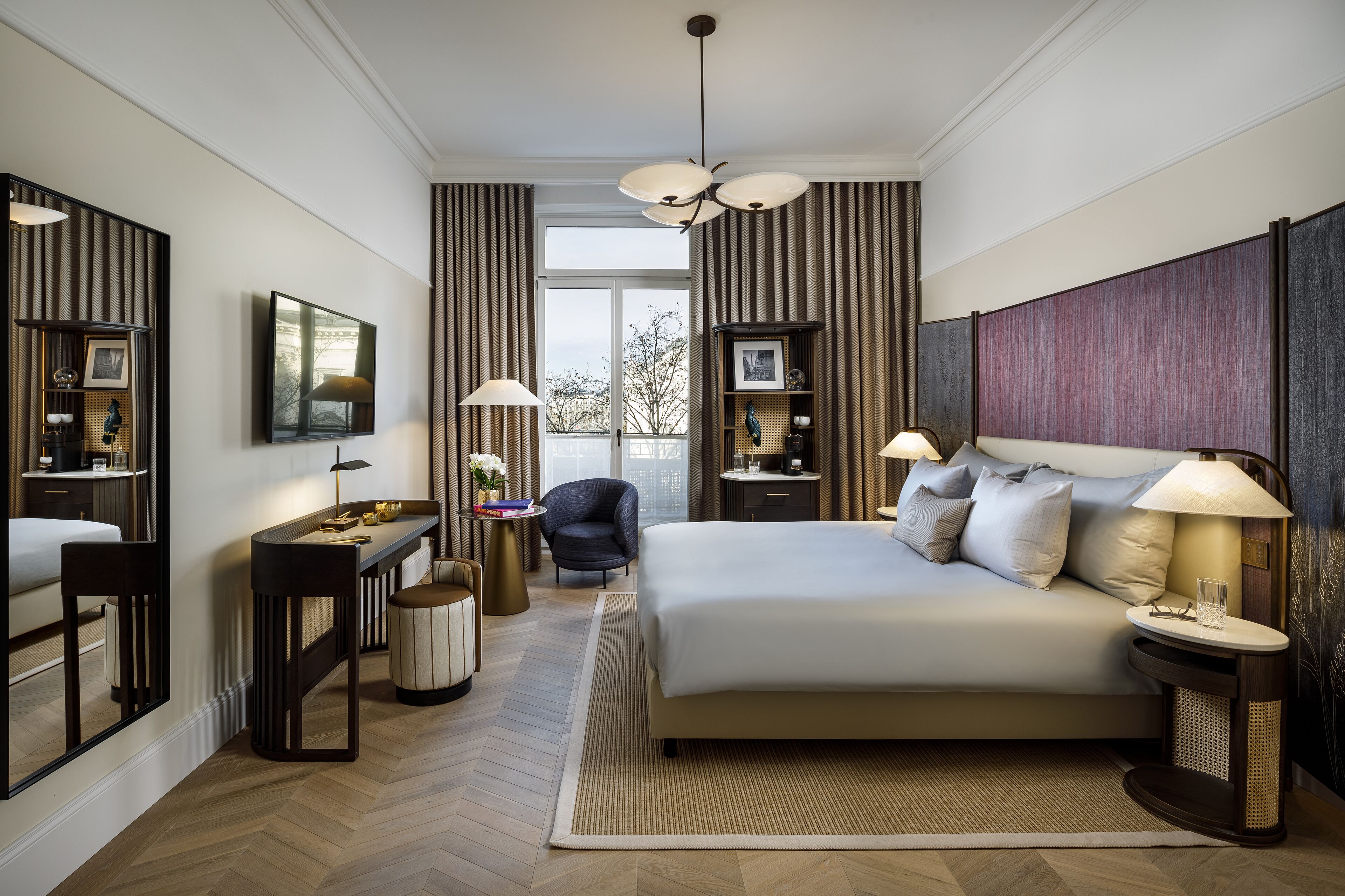 Una habitación de hotel moderna con una cama grande, un escritorio con una silla, un televisor y una ventana con cortinas.