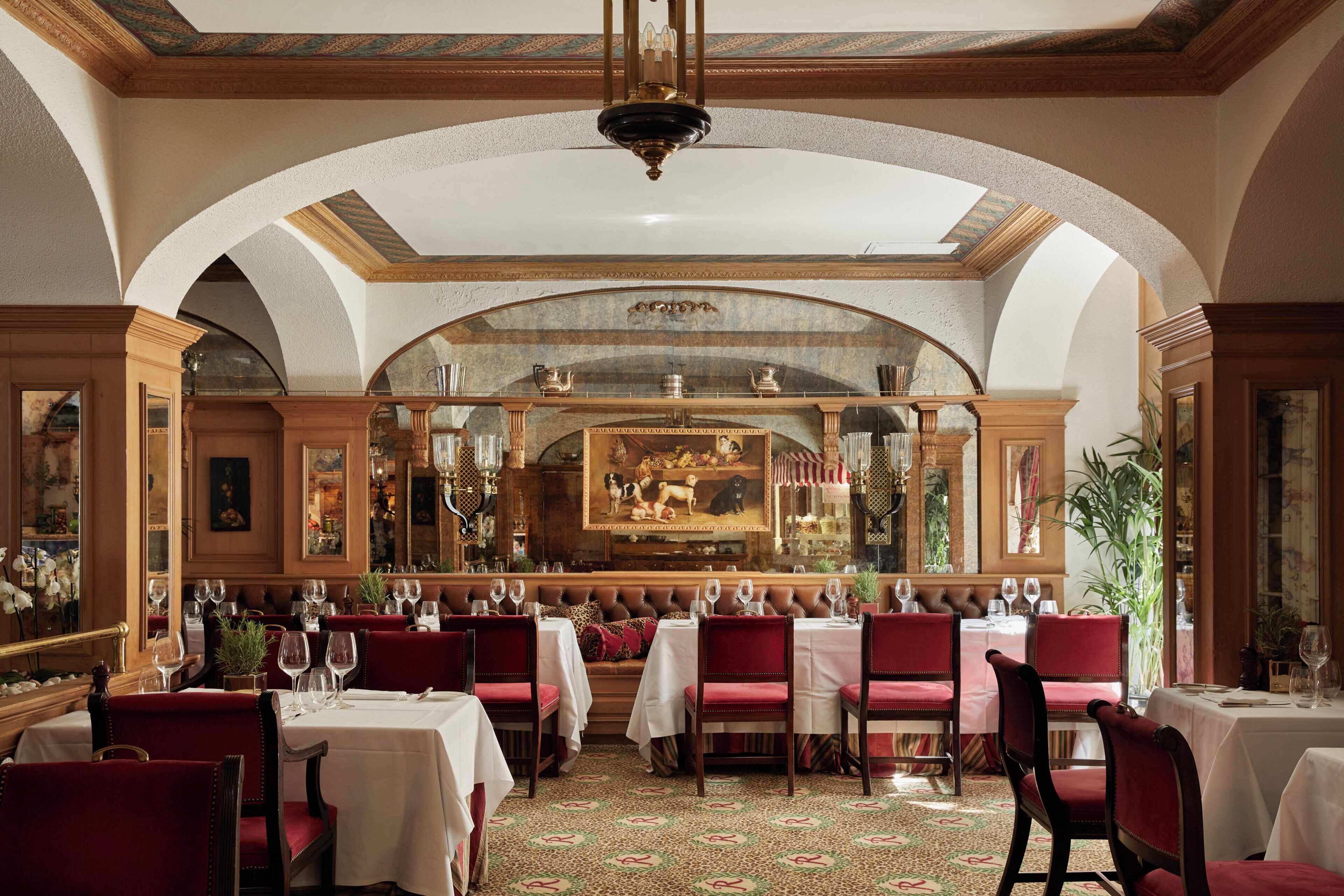 Ein formeller Speisesaal mit gedeckten Tischen, einer hohen Gewölbedecke und klassischen architektonischen Details.
