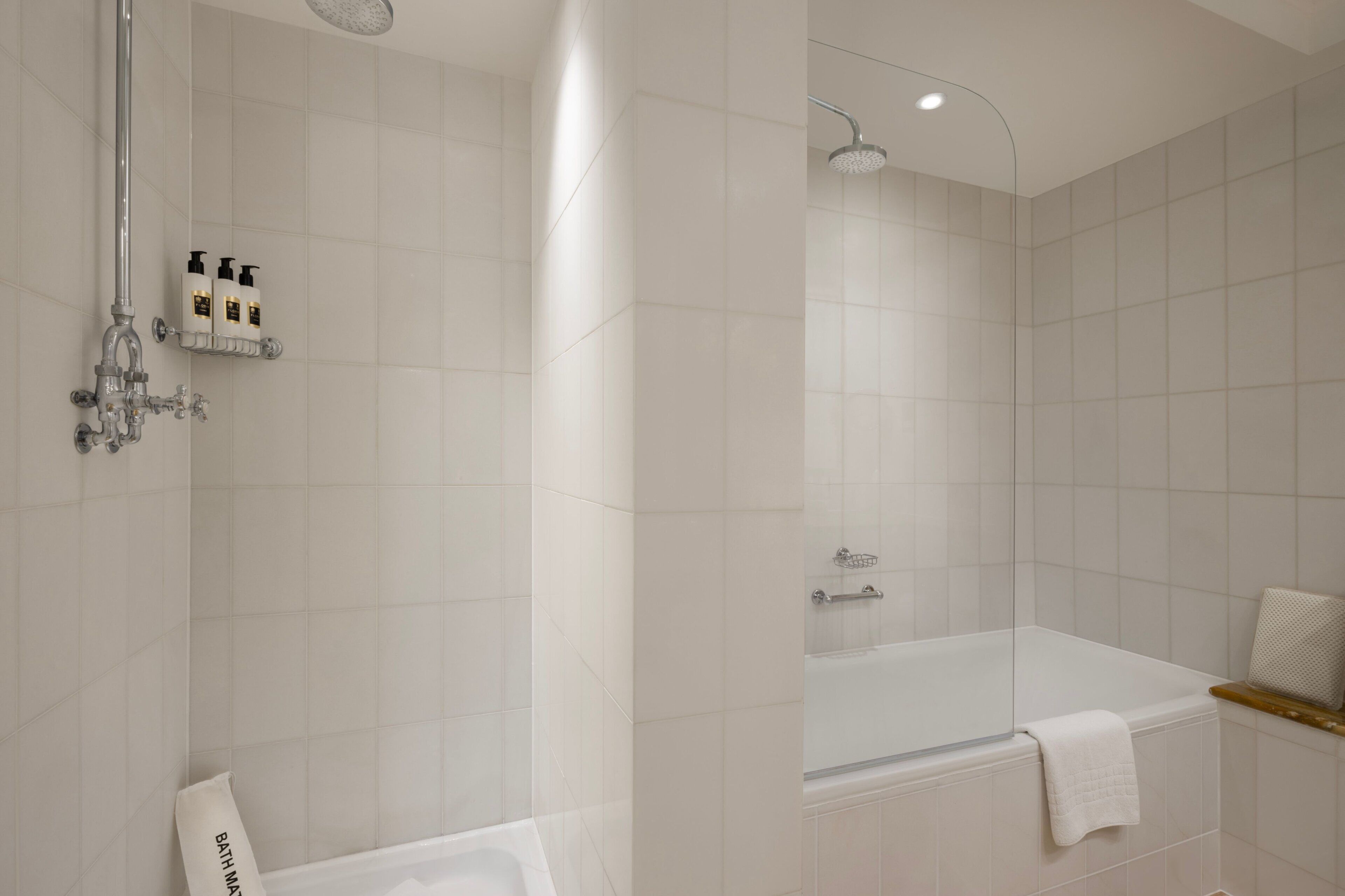 Ein modernes Badezimmer mit Badewanne, Dusche und einer gläsernen Duschkabine.