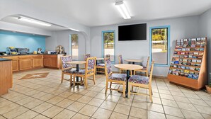 A restaurant with wooden tables and chairs, a kitchen area, and a display of menus. - Days Inn by Wyndham Cleveland TN (Cleveland)