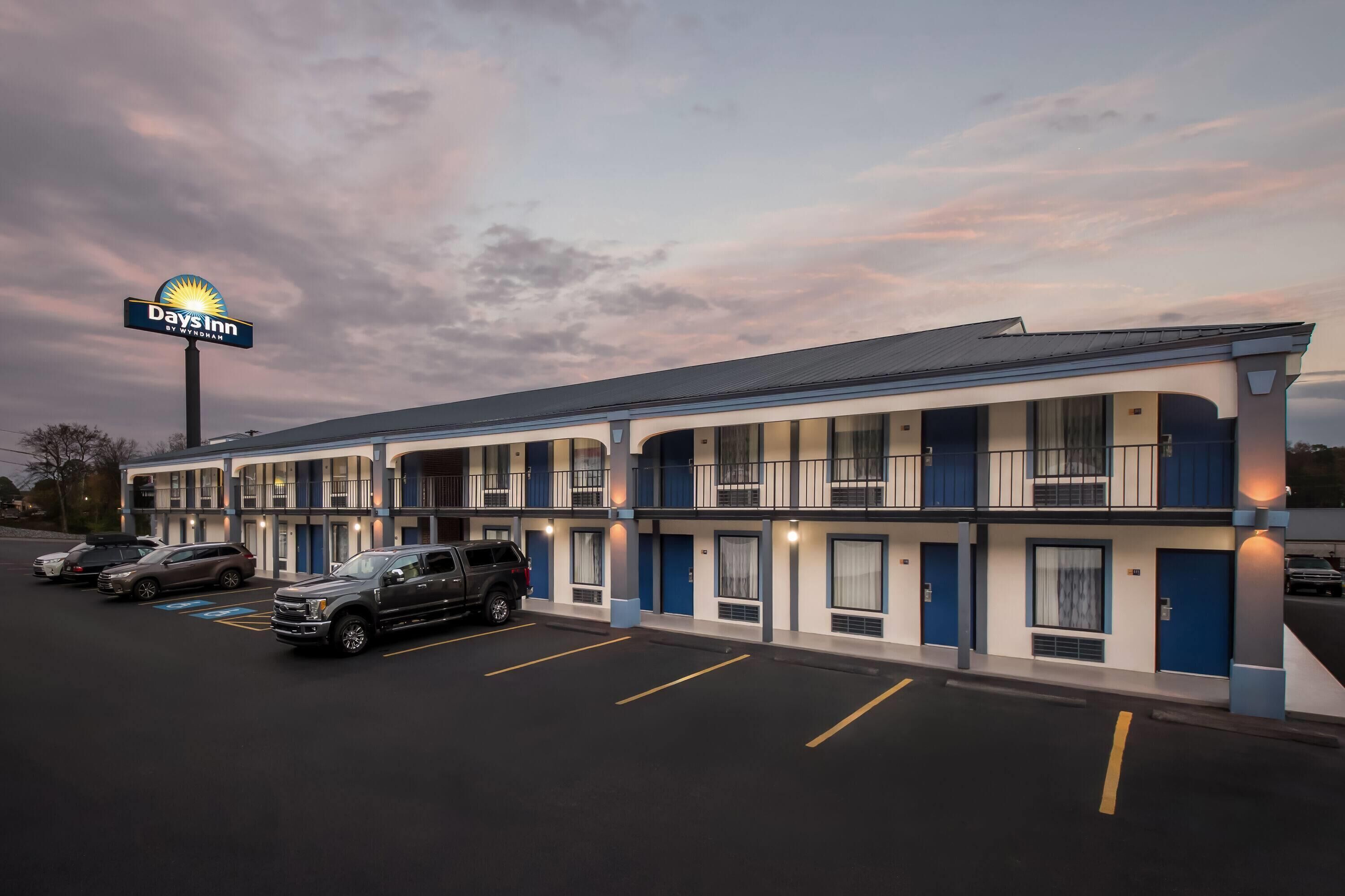 Un motel comprenant plusieurs chambres, un parking et une enseigne indiquant qu’il s’agit d’un établissement Days Inn.