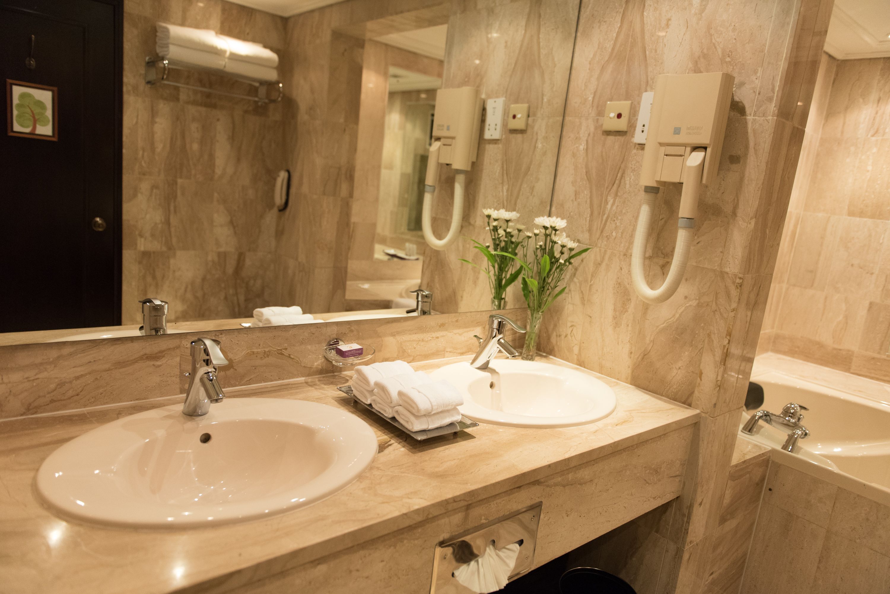 A bathroom with two sinks, a mirror, a towel rack, and a shower.