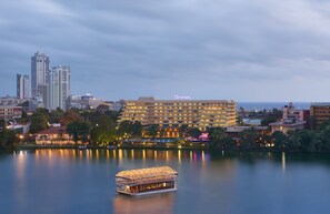 A hotel with a large building and a boat on the water.