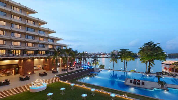 Un hotel con piscina, asientos al aire libre y vista al agua.