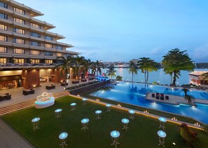 A hotel with a pool, outdoor seating, and a view of the water. - Cinnamon Lakeside Colombo (Colombo)