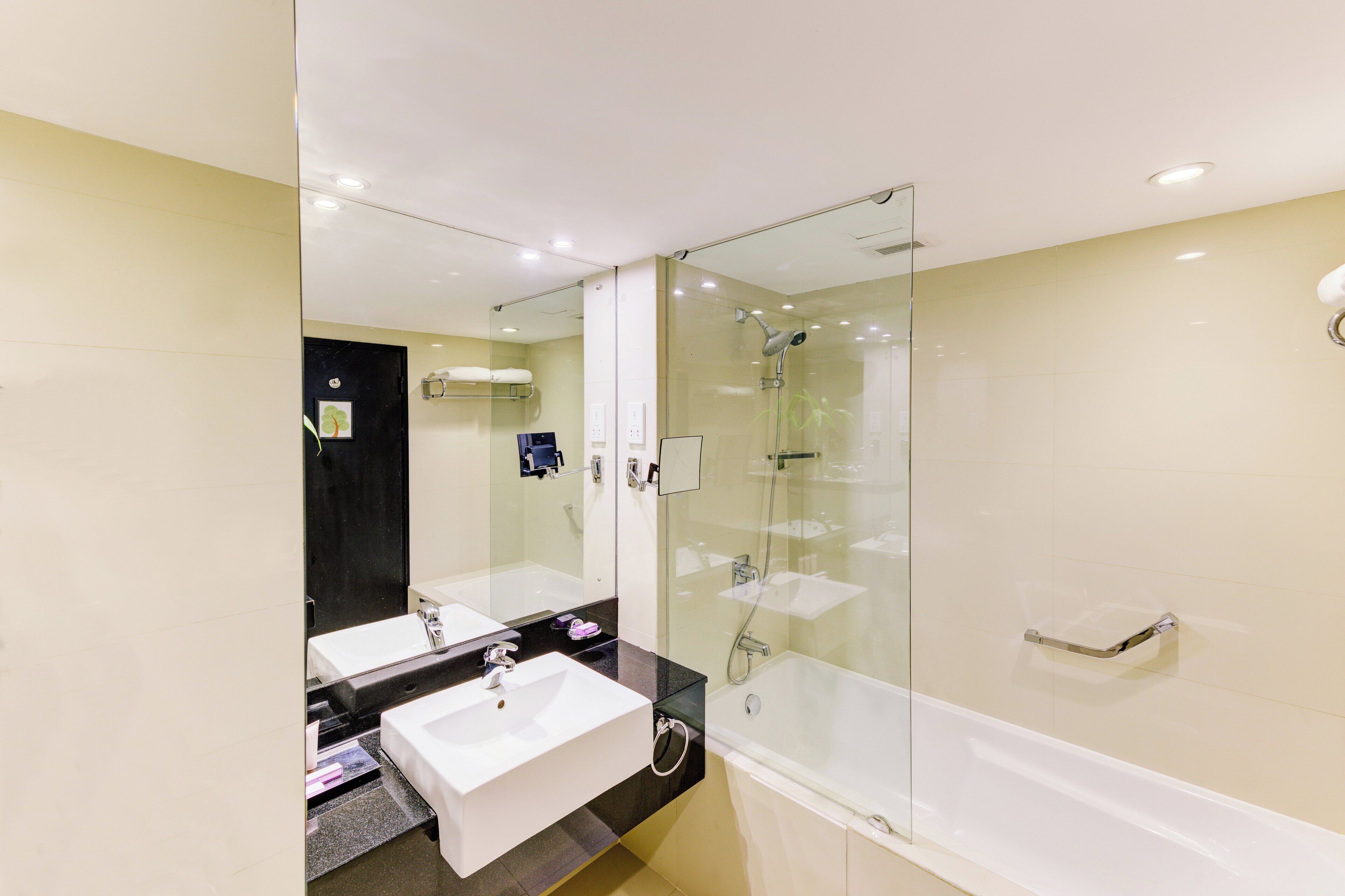 Un baño moderno con dos lavabos, ducha con cerramiento de vidrio y tocador con espejo.
