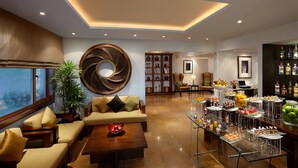 Una sala moderna con un sofá, una mesa de centro y una mesa de vidrio para exhibir aperitivos.