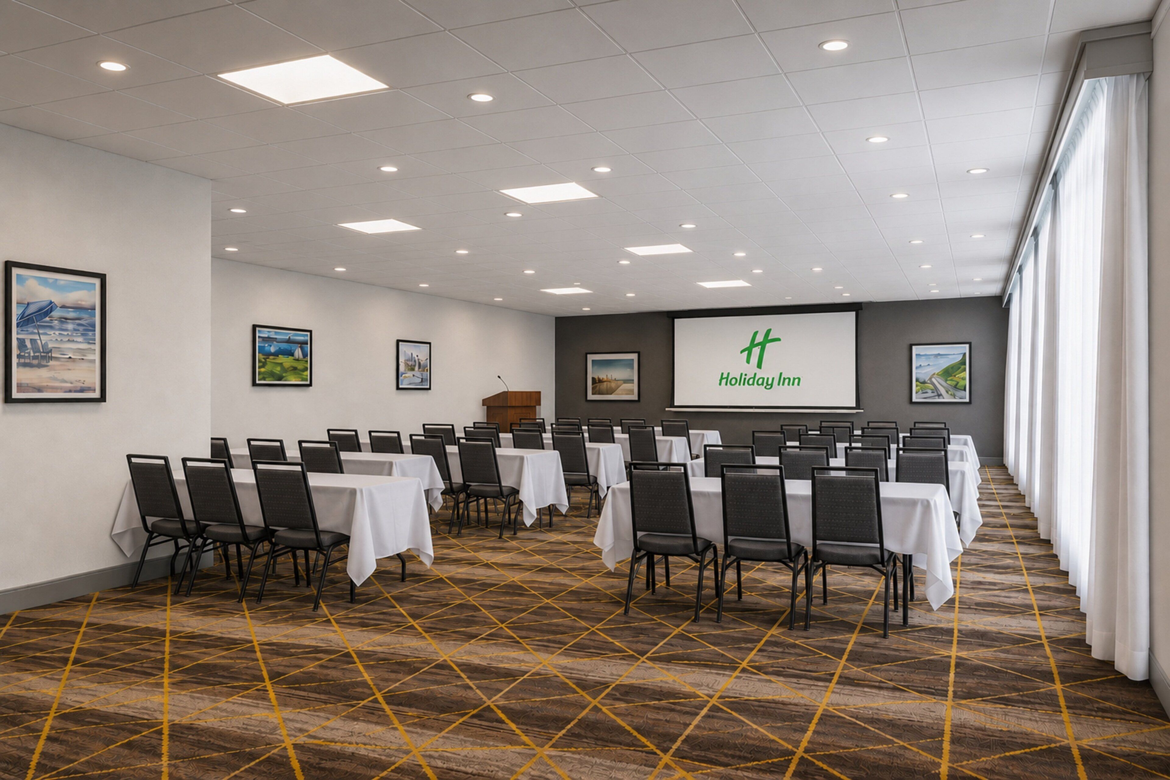 Uma sala de conferências com mesas, cadeiras, um pódio e uma tela de apresentação com o texto 'Holiday Inn'.
