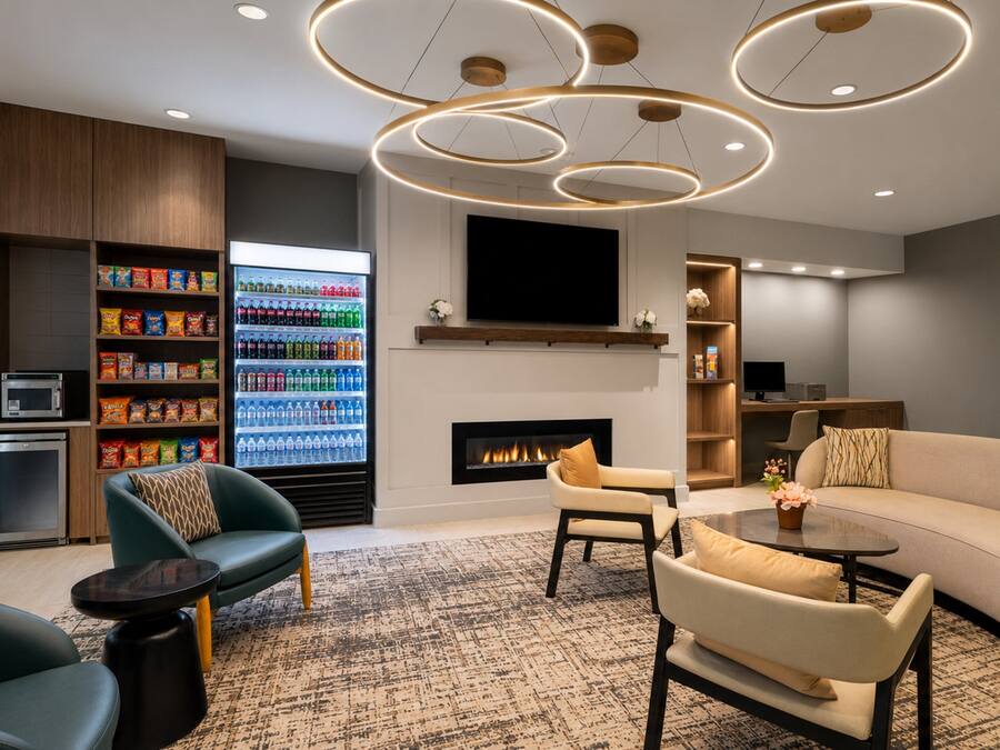 Una sala de estar moderna con chimenea, zona de estar y refrigerador para bebidas.