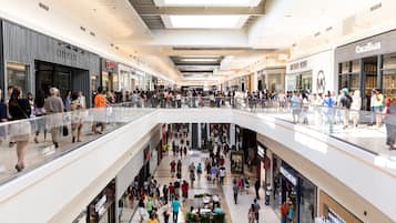 A multi-level shopping mall with various stores, including a visible Starbucks and a Bath & Body Works.