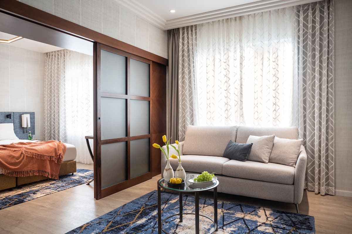 A modern living room with a sofa, a coffee table with decorative items, and a sliding door.