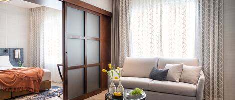 A modern living room with a sofa, a coffee table with decorative items, and a sliding door.