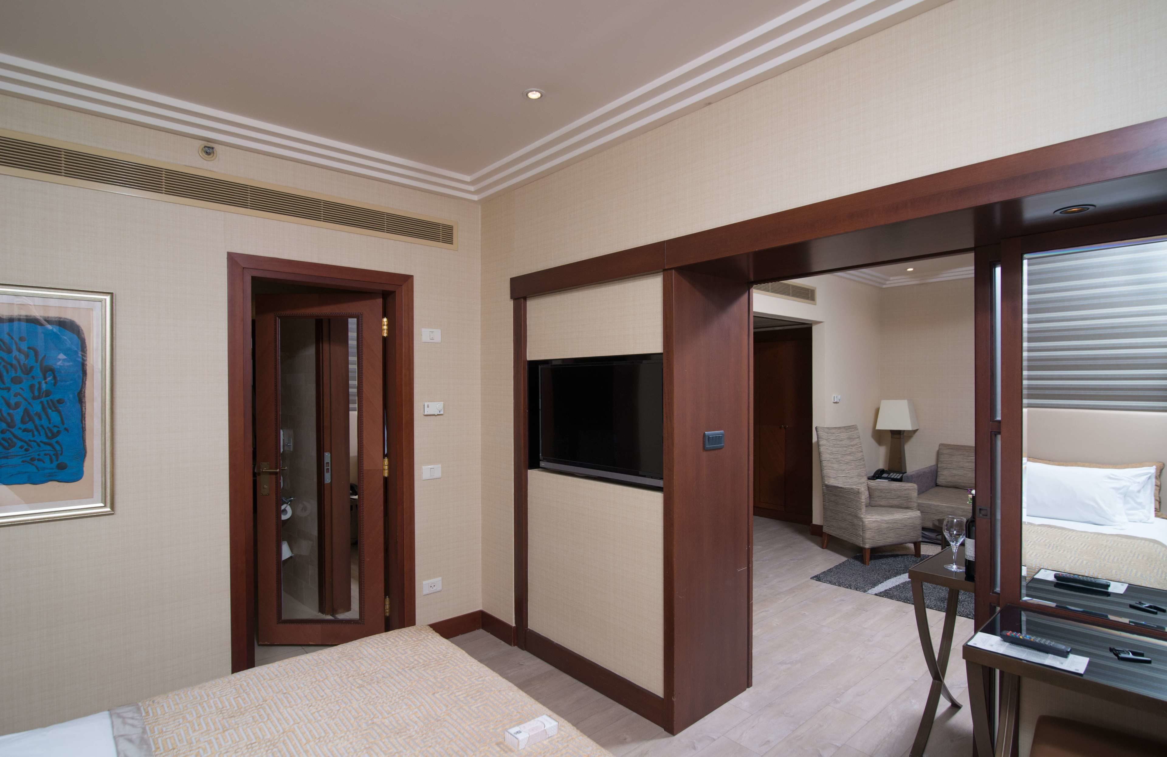 Una habitación de hotel con cama, televisión, escritorio y una silla.