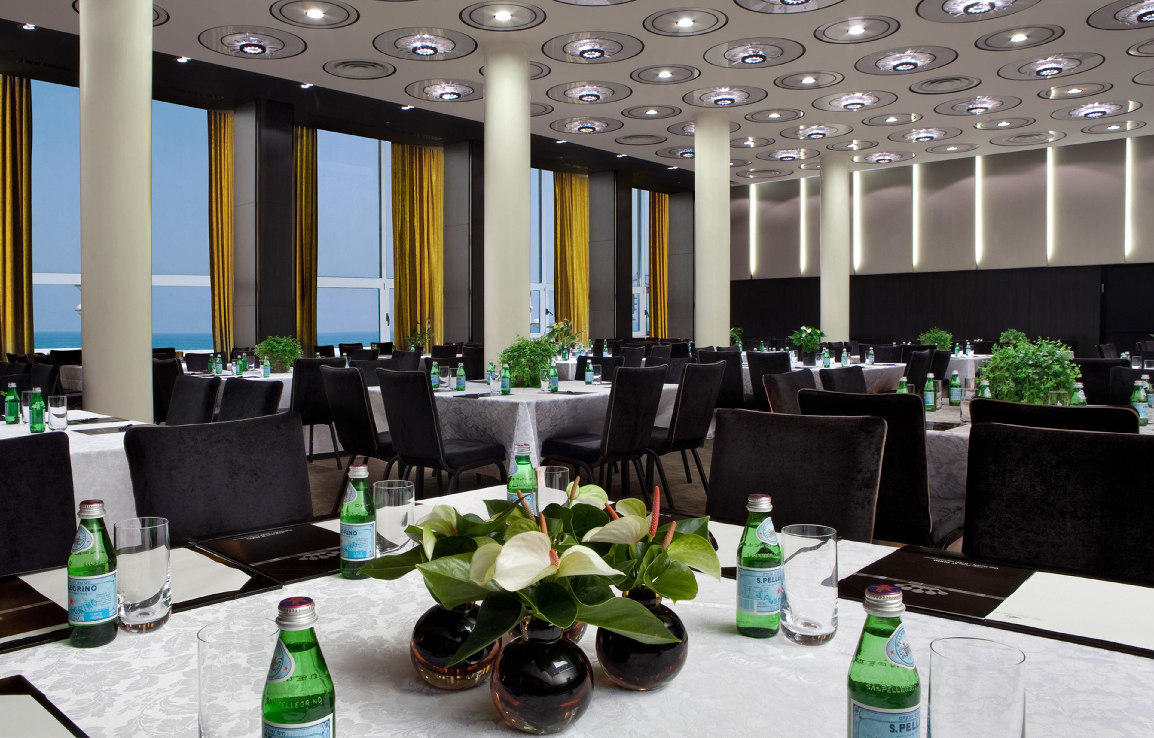 A conference room with tables set for a meeting, equipped with water bottles and glasses.