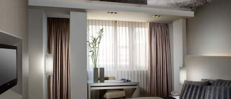 Une chambre d’hôtel moderne équipée d’un lit, d’un bureau et d’une télévision.