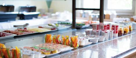 Un bufé con diversas opciones de comida y bebidas.