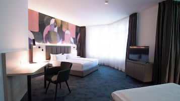 Quarto de hotel com cama, escrivaninha, cadeira, televisão e uma grande pintura abstrata na parede.