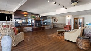 A spacious living area with a fireplace, comfortable seating, and a large window overlooking the interior.