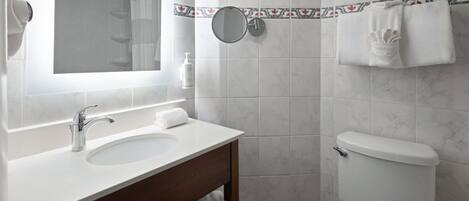 A bathroom with a white sink, a mirror, a toilet, and a towel rack.