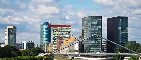 A modern cityscape with a prominent bridge, high-rise buildings, and a river.