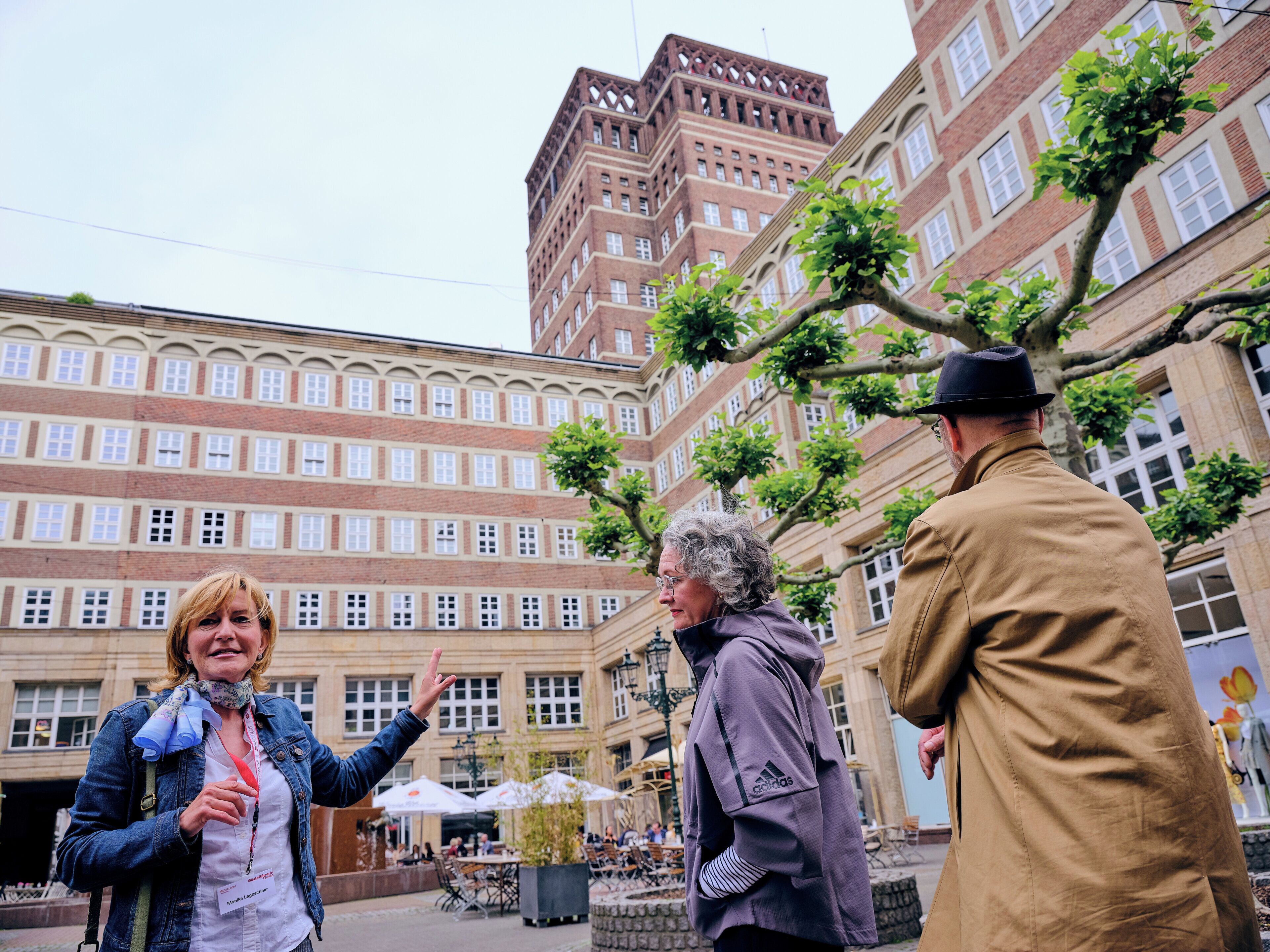 Een binnenplaats met een groot bakstenen gebouw, terrasmeubels en een fontein.