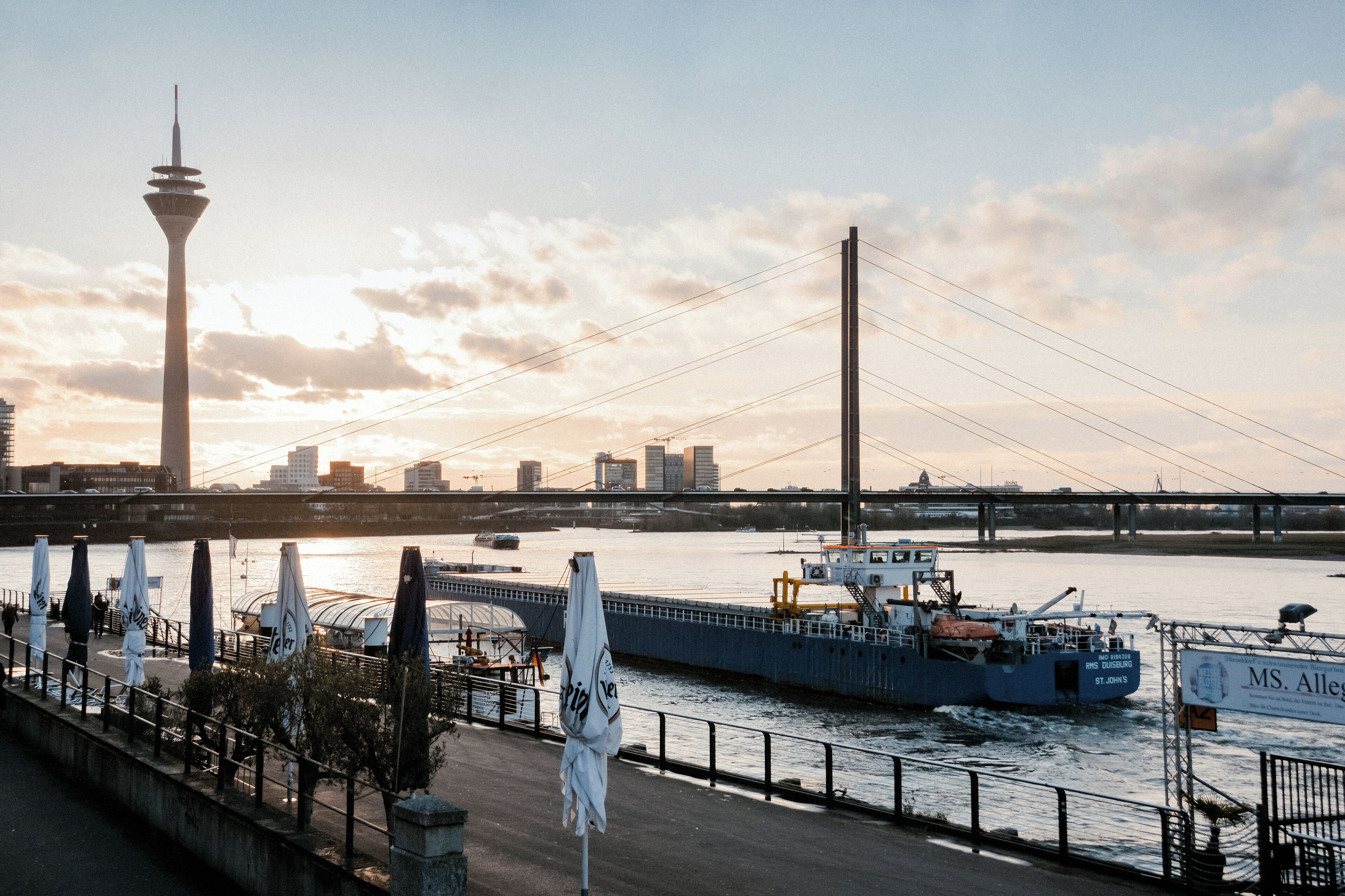 A river with a bridge, a tower, and a boat.