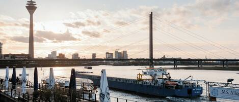 A river with a bridge, a tower, and a boat.